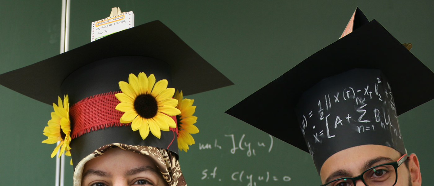 Two PhD Students with doctoral hats