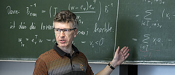 Prof. Kanzow vor Tafel mit mathematischen Formeln