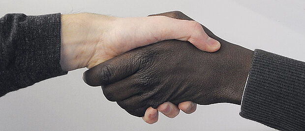 Shaking hands in different hand colours