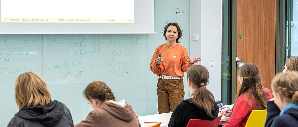 Eine Dozentin hält für die Schülerinnen und Schüler des Mathe-Camps der Universität Würzburg einen Vortrag.