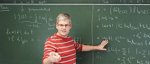 Professor Daniel Wachsmuth in front of a blackboard