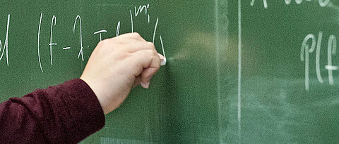 Mathematical formulas on a green chalkboard